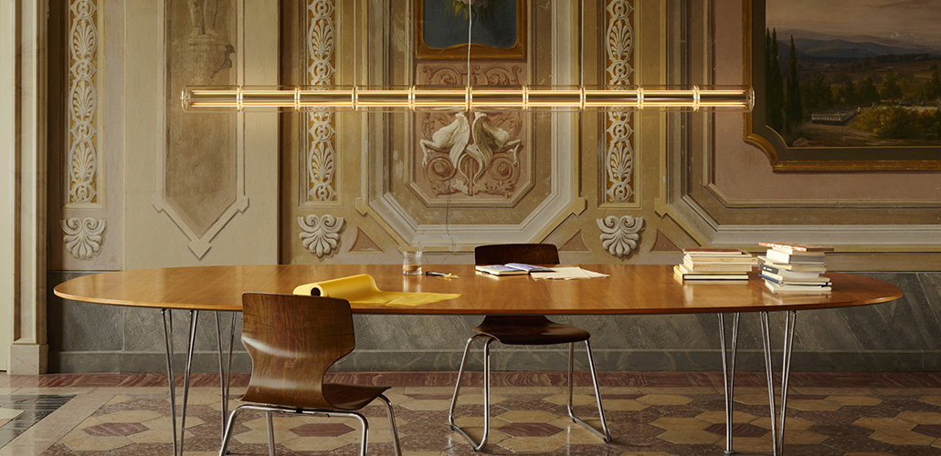 A modern lighting fixture hanging over a large table.
