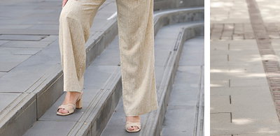 Ein Model trägt ein roséfarbenes Shirt mit Bindebändern und eine champagner-goldfarben Leinenhose mit Lurexfaden
