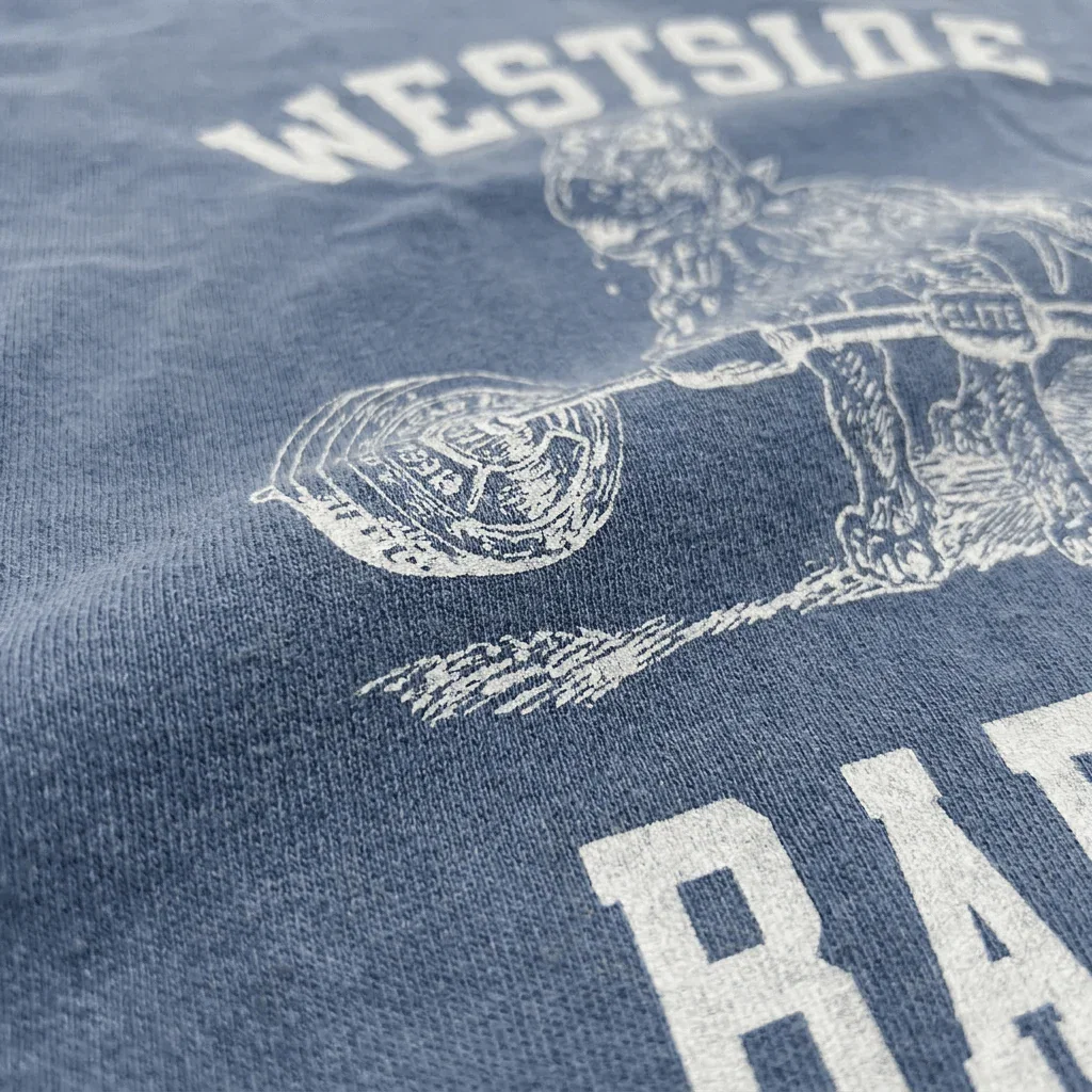Macro close-up of garment-dyed cotton fabric texture on Westside Barbell Washed Denim t-shirt