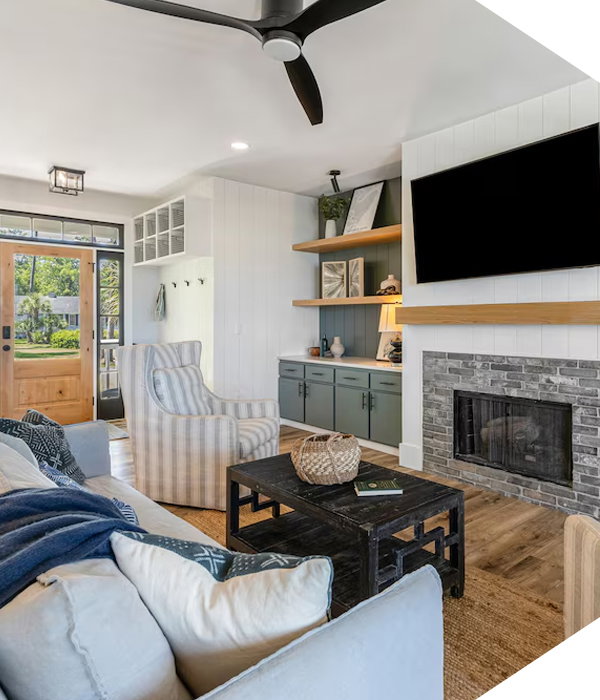 Bright living room with couch, armchair, coffee table, fireplace, and wall-mounted TV.
