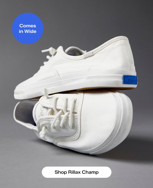 A close-up view of a pair of the Rillax Champ Washed Twill Slip-Ons in snow white, one shoe on top of the other. A callout on the image notes that the style Comes in Wide. Shop Rillax Champ.