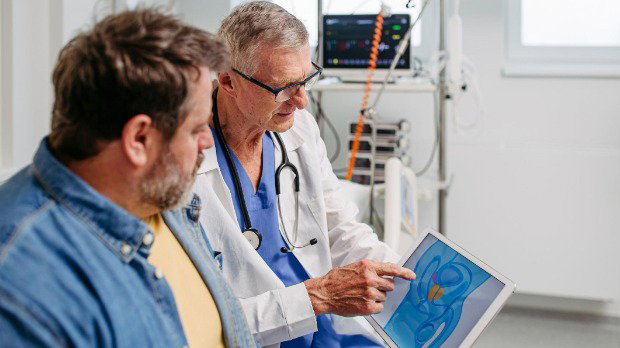 A doctor looks at a scan with a patient.
