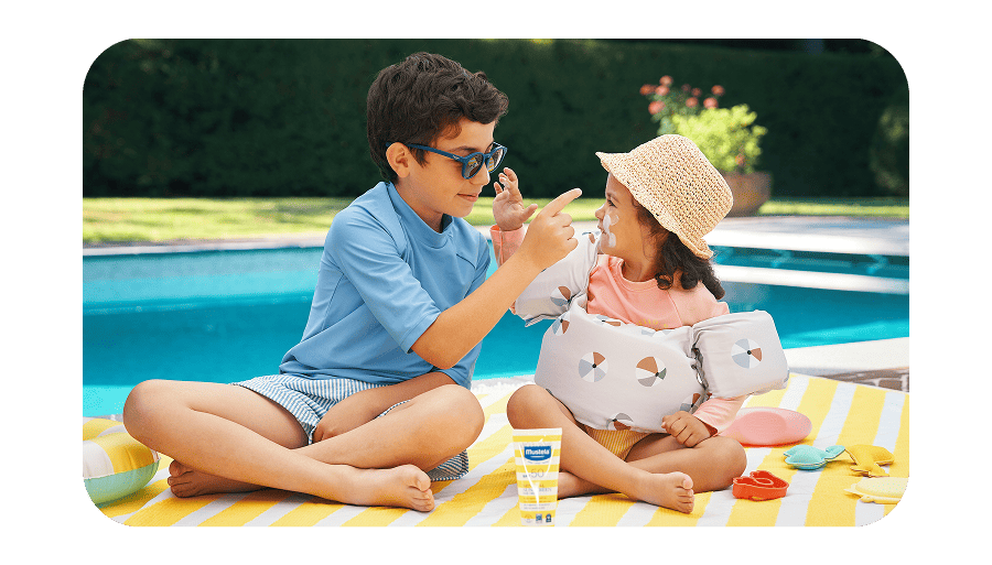 Brother and sister putting sun screen on each lotion