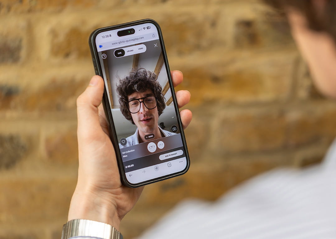 A man using a smartphone to virtually try on glasses