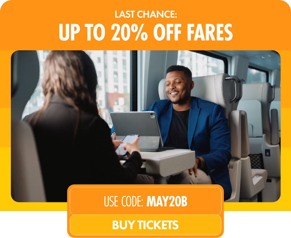 Promotional graphic advertising up to 20% off fares features two people sitting at a table on a modern train. A call-to-action highlights the discount code MAY20B and a button inviting viewers to buy tickets.