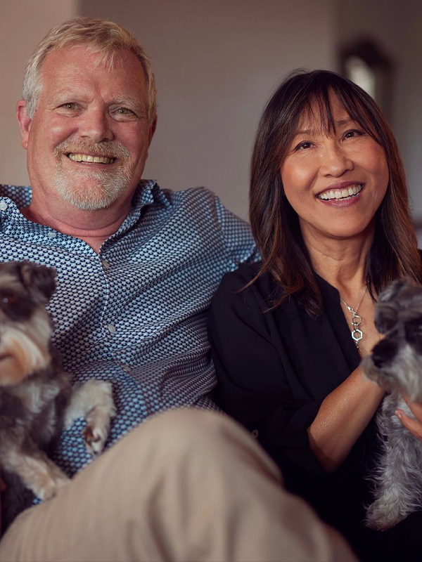 Image of Bob Ehlers smiling with his wife and two little dogs.