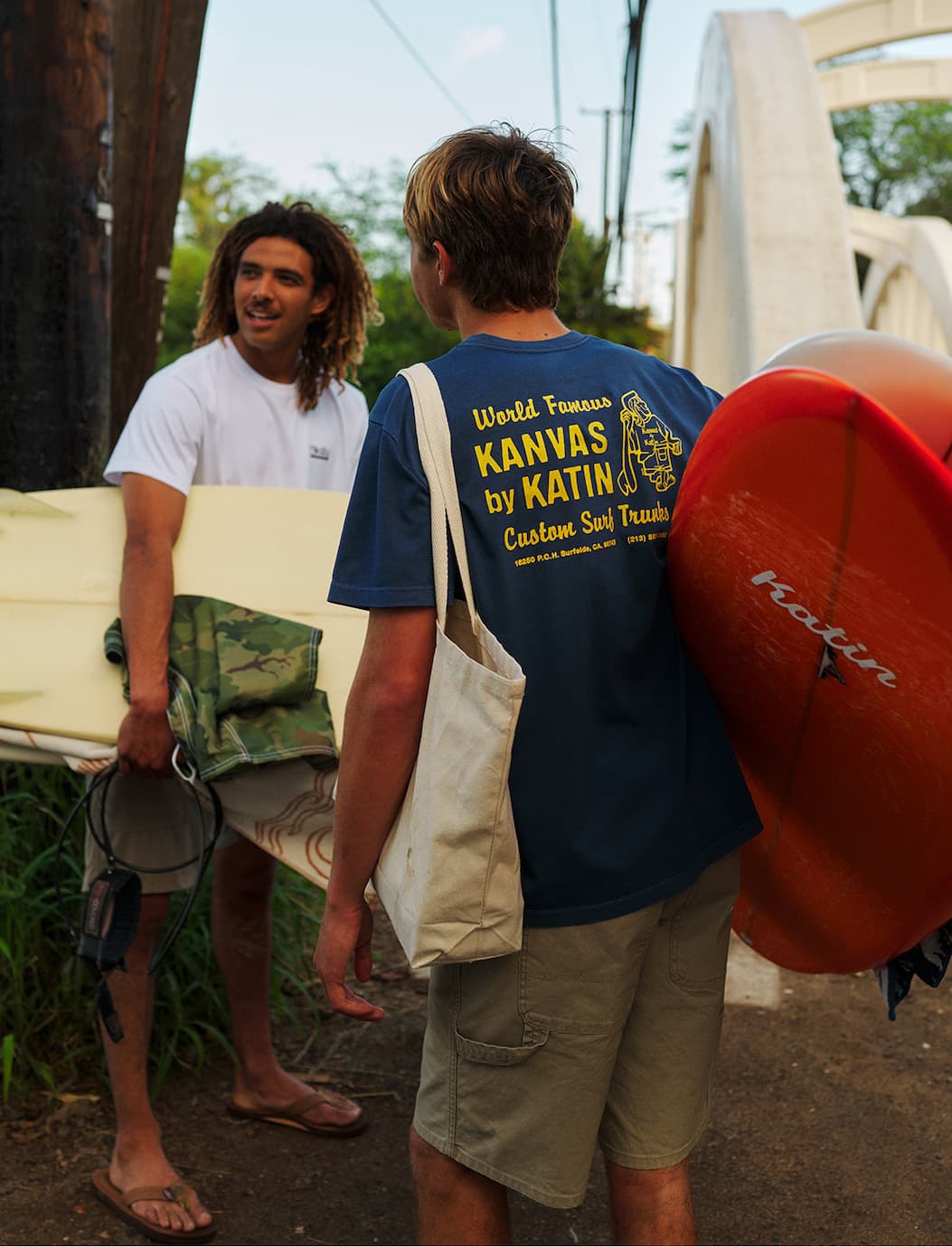 Two male surfers in our graphic tees walking to the next surf spot