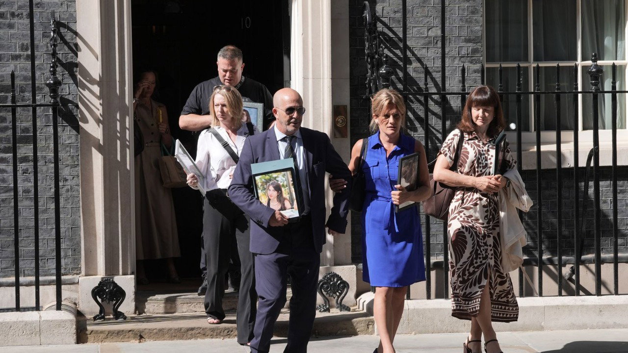 Bereaved parents who tragically lost their children to suicide leave 10 Downing Street, central London, following their meeting with Prime Minister Sir Keir Starmer. Five smartly dressed people exit the open door and walk on the pavement.