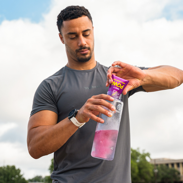 Man pouring a packet of eboost into a water bottle