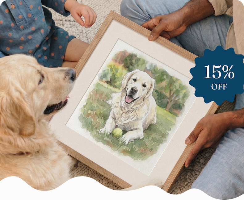 A couple sitting together holding a framed watercolour portrait of a golden retriever, with the dog sitting beside them
