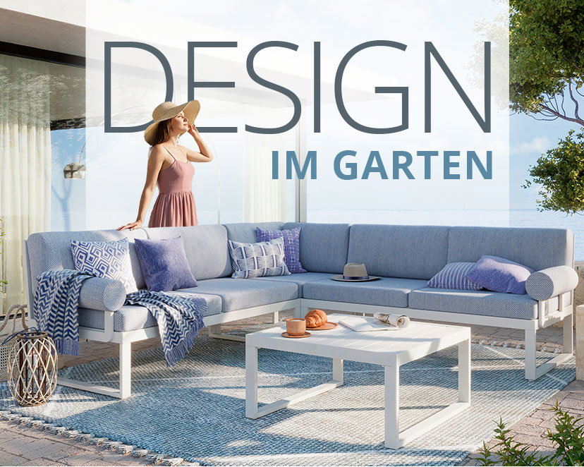 Der Header zeigt eine elegante Outdoor-Sitzecke auf einer gepflasterten Terrasse mit Blick auf das Meer. Im Mittelpunkt steht eine große, L-förmige Garten-Lounge mit weißen Gestellen und hellblauen bzw. hellgrauen Polstern. Die Couch ist mit verschiedenen Zierkissen in Blau- und Mustertönen sowie einer passenden Decke dekoriert. Davor befindet sich ein quadratischer, weißer Couchtisch, auf dem ein Croissant und eine Kaffeetasse serviert sind. Die gesamte Sitzgruppe steht auf einem hellblauen Outdoor-Teppich. Eine Frau mit einem hellen Sommerhut und einem rosa Kleid steht elegant hinter dem Sofa und blickt in die Ferne.