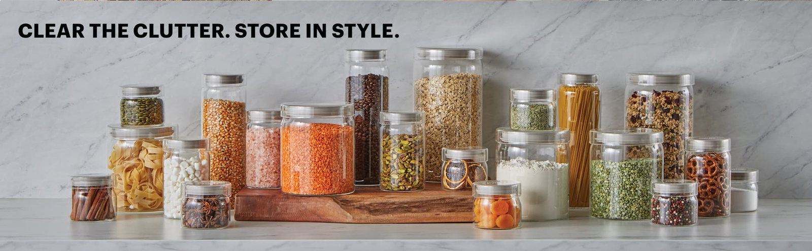 Pyrex glass canisters in multiple sizes filled with pantry staples on a kitchen counter.