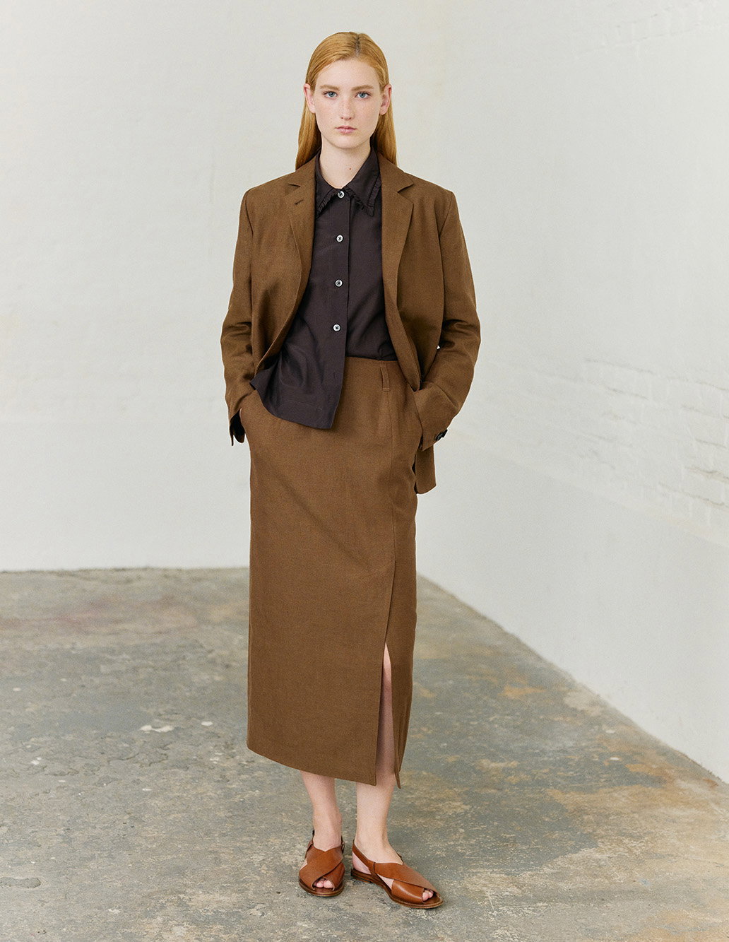 Brown linen tailoring layered over a dark shirt