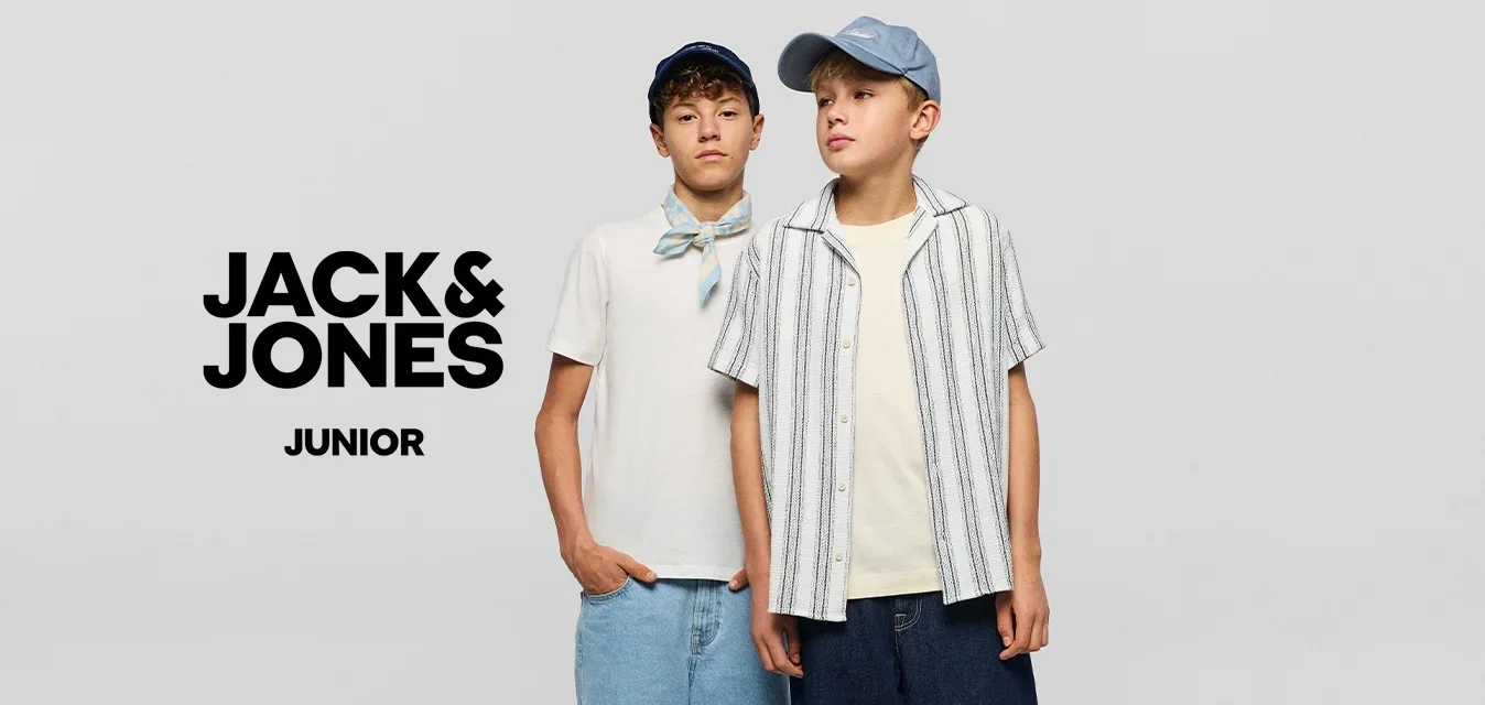 Twee jongens dragen casual zomerkleding en petten, staand naast elkaar tegen een eenvoudige lichte achtergrond.
