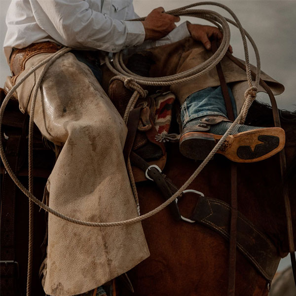 Cowboy sitting on a horse wearing a pair of Tony Lama boots.