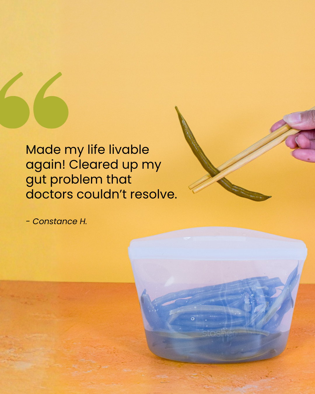 A hand holds chopsticks, picking up a green bean from a clear reusable container with more green beans. A large green quote mark and a testimonial about gut hea