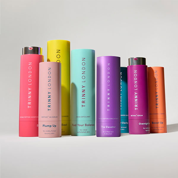 Colorful Trinny London skincare product bottles arranged in a row.