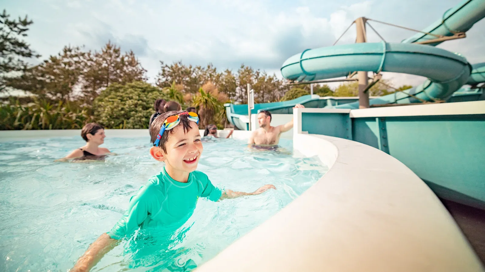 Boy smiling with his family in the blue lagoon on a sunny day