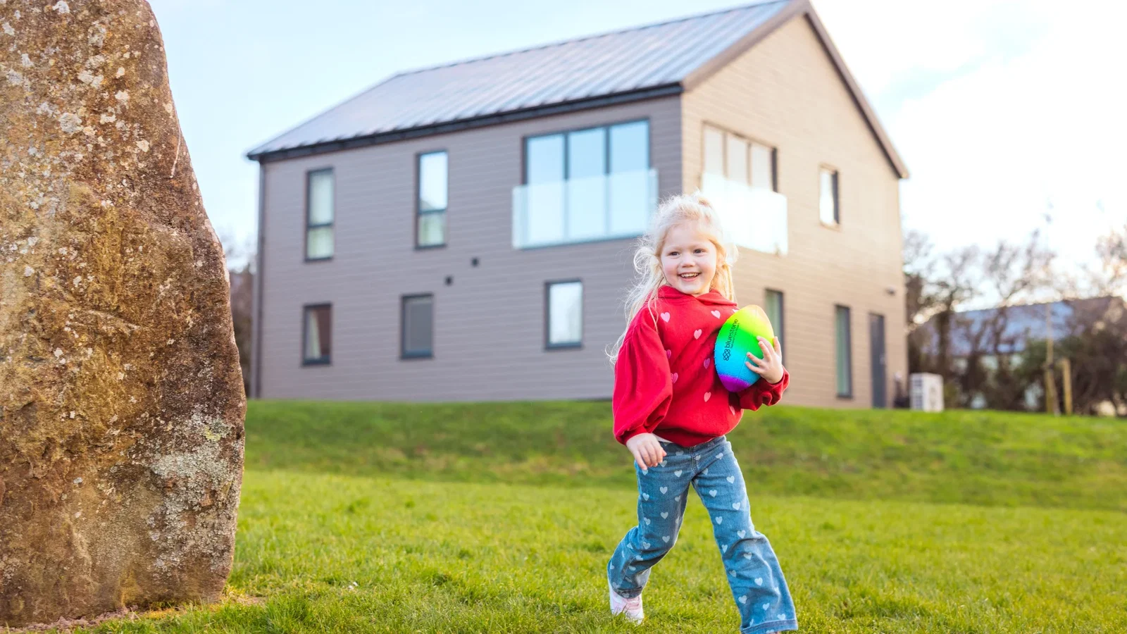 Girl running on the grass outside next to a platinum lodge