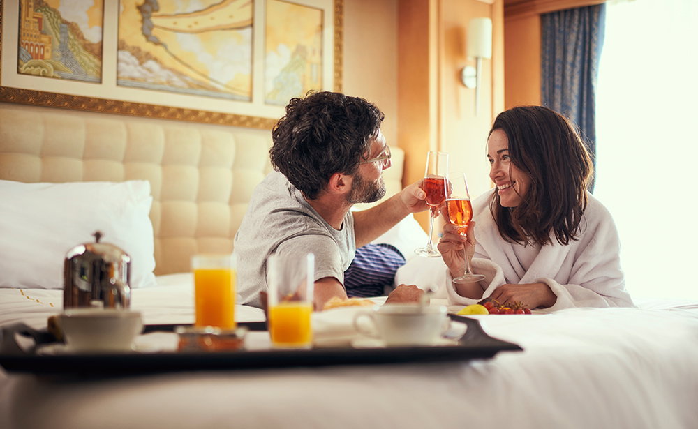 A couple enjoying champagne in their stateroom