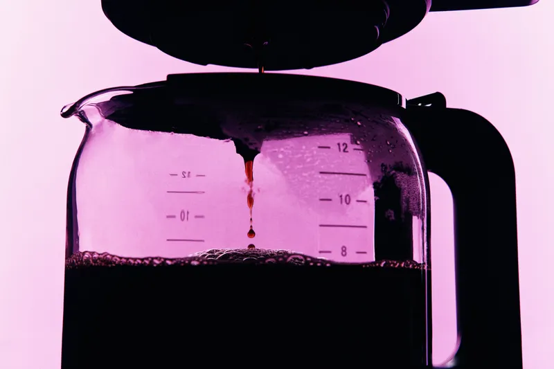 The carafe of a Braun drip coffee maker filling up with coffee.