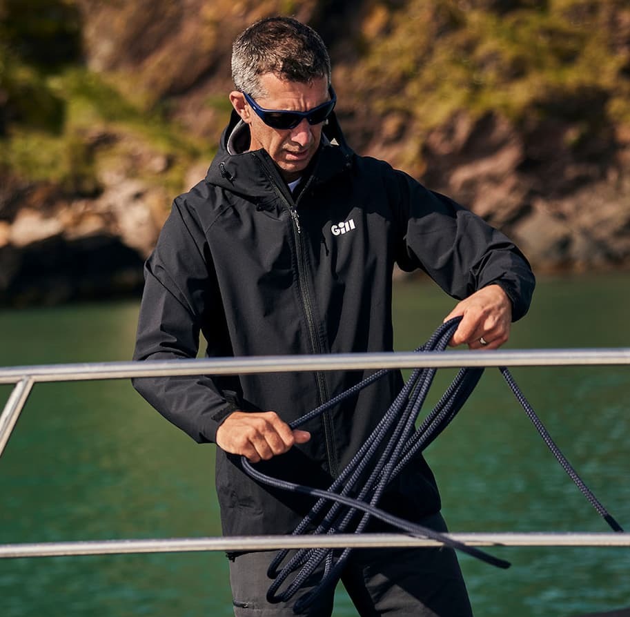 Man pulling a rope wearing a Black Voyager Jacket