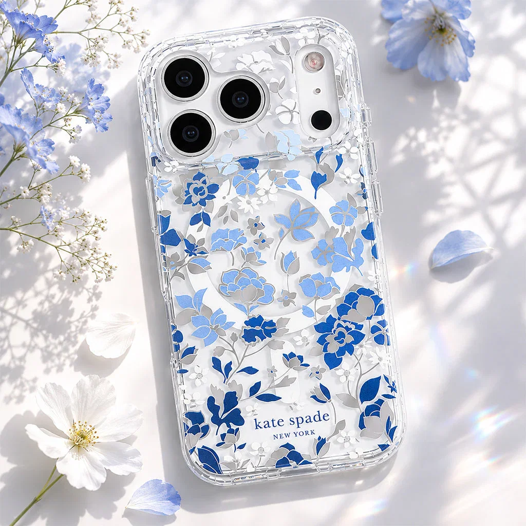 Clear Kate Spade phone case with blue and gray floral pattern on white background surrounded by flowers.