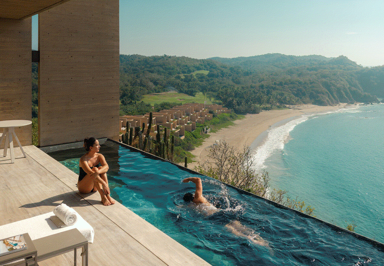 Hero video featuring three scenes: 1) Woman sitting on the edge of her private infinity pool as a man swims by. 2) Woman walking through green courtyard garden path, towards a sitting area. 3) 'Three people hiking through forest with a snow-covered mountain range in the background.