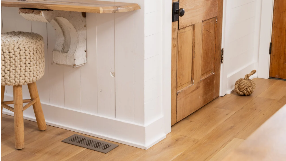 Sanibel grille on a wide wood floor next to rustic panelling