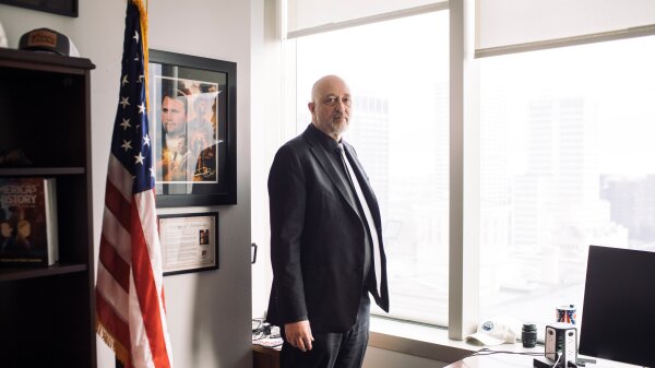 Republican state Rep. Gary Click, from northern Ohio, stands in his office by a window and an American flag. 