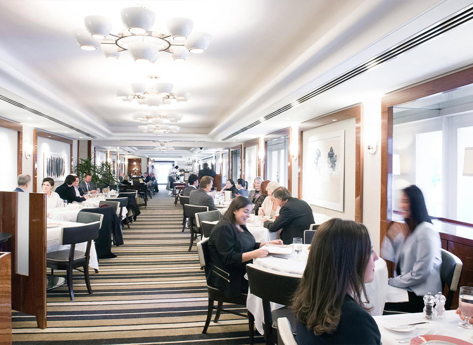 a group of people sitting at tables in a restaurant