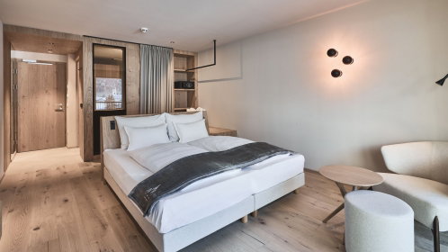 Hotel Doppelzimmer mit Doppelbett und gemütliche Sessel und Tisch
