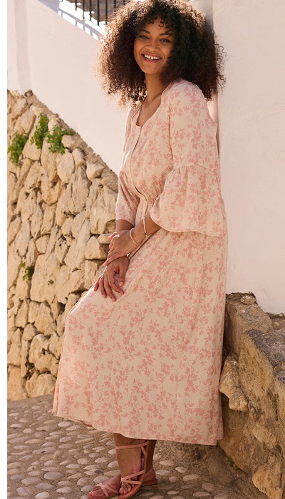Model in cremefarbenem Sommerkleid mit rosa Blümchendruck