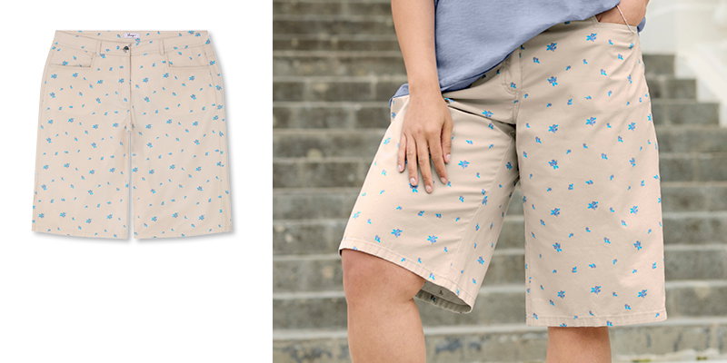 Model in kurzer beigefarbener Sommershorts mit blauen Blümchen