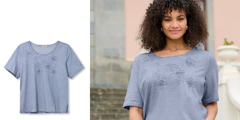 Model in rauchblauem Shirt mit Blumenstickerei vorn