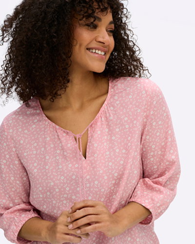 Model mit hellrosa Tunika mit weißen Millefleurs-Blümchen