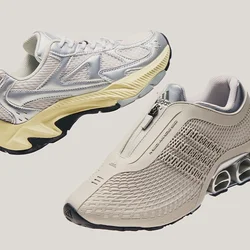 Une paire de chaussures de sport de couleur claire, l'une avec fermeture éclair et design en mesh, l'autre avec lacets et semelle épaisse, sur un fond uni.