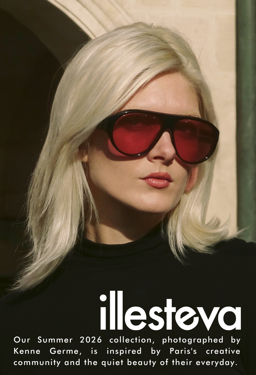 A campaign portrait of a woman with platinum blonde hair wearing oversized black aviator sunglasses with red-tinted lenses. She is dressed in a black turtleneck. Large white text below reads 