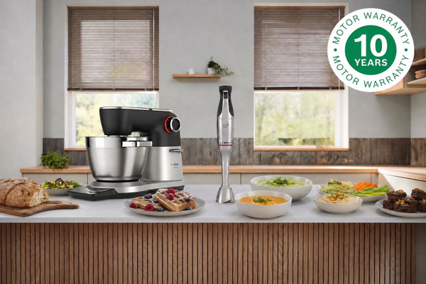 Robot pâtissier et mixeur plongeant Bosch sur un comptoir de cuisine avec divers plats. Garantie moteur 10 ans.
