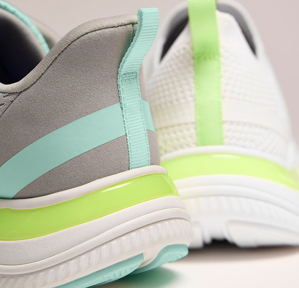 A closeup on the heels of two BlissMove sneakers showcasing the colorful contrasting heel tabs and midsoles.