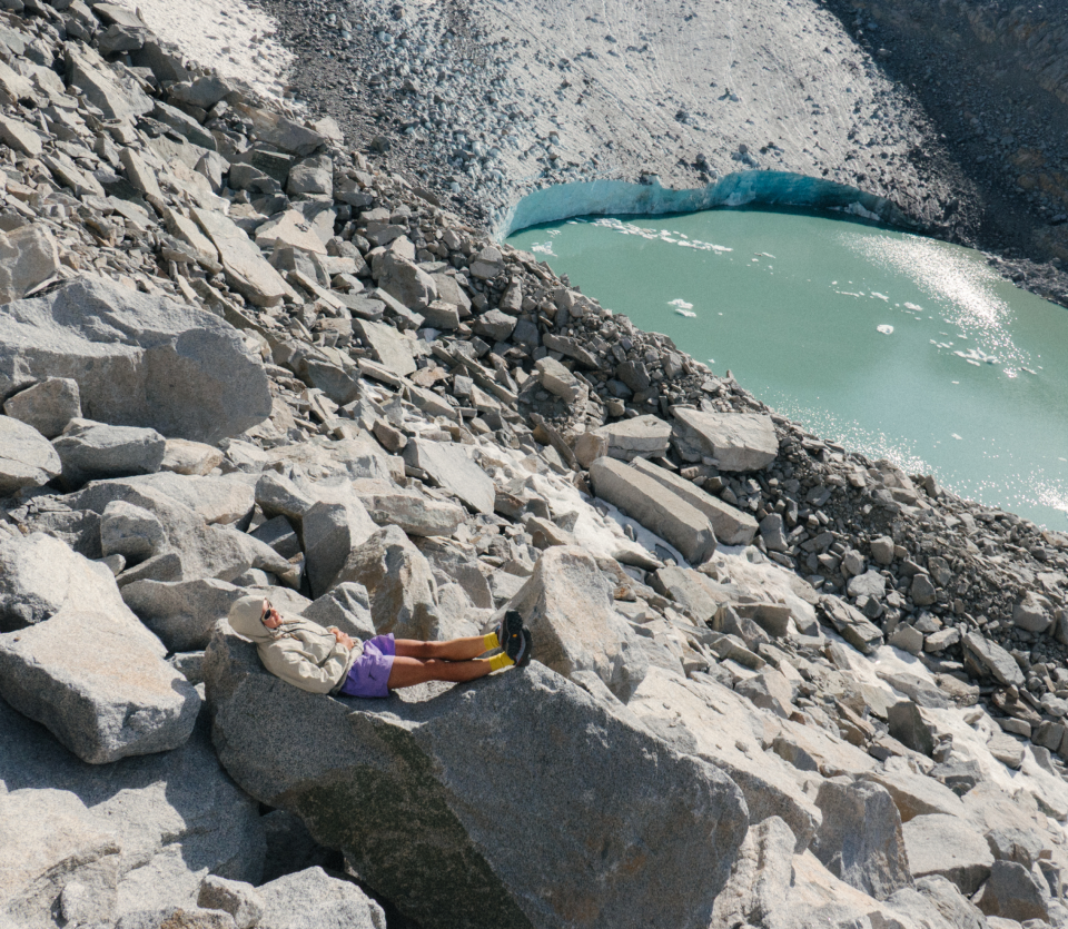 Emi sitting on rocks overlooking water.
