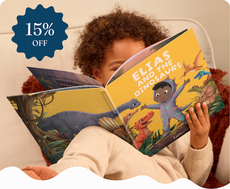 A young child lying back reading a personalised illustrated book titled "Elias and the Dinosaurs"
