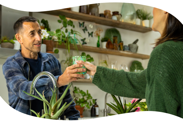 Couple passing a glass of water