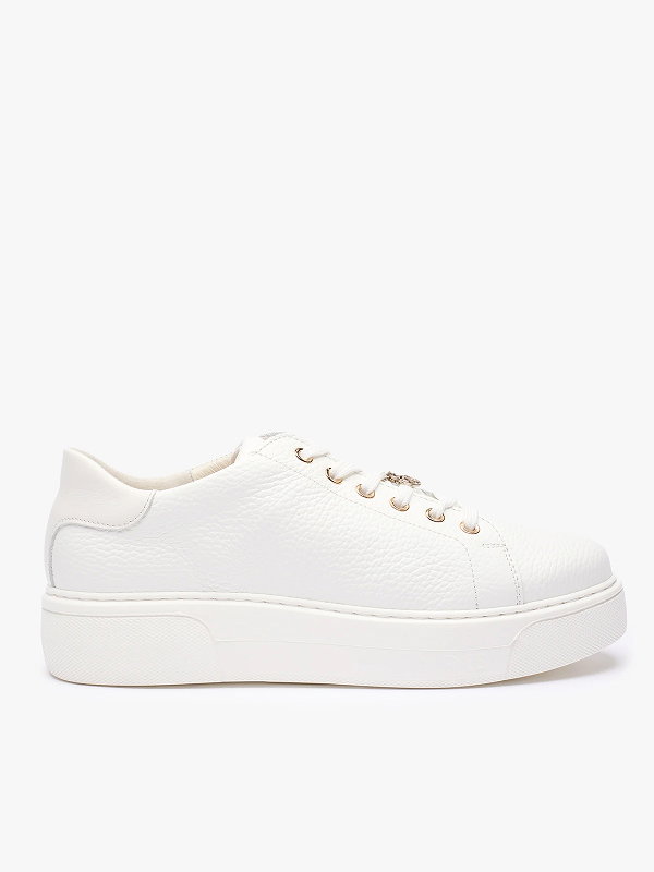Side view of a white leather trainer with a textured surface and lace-up design.