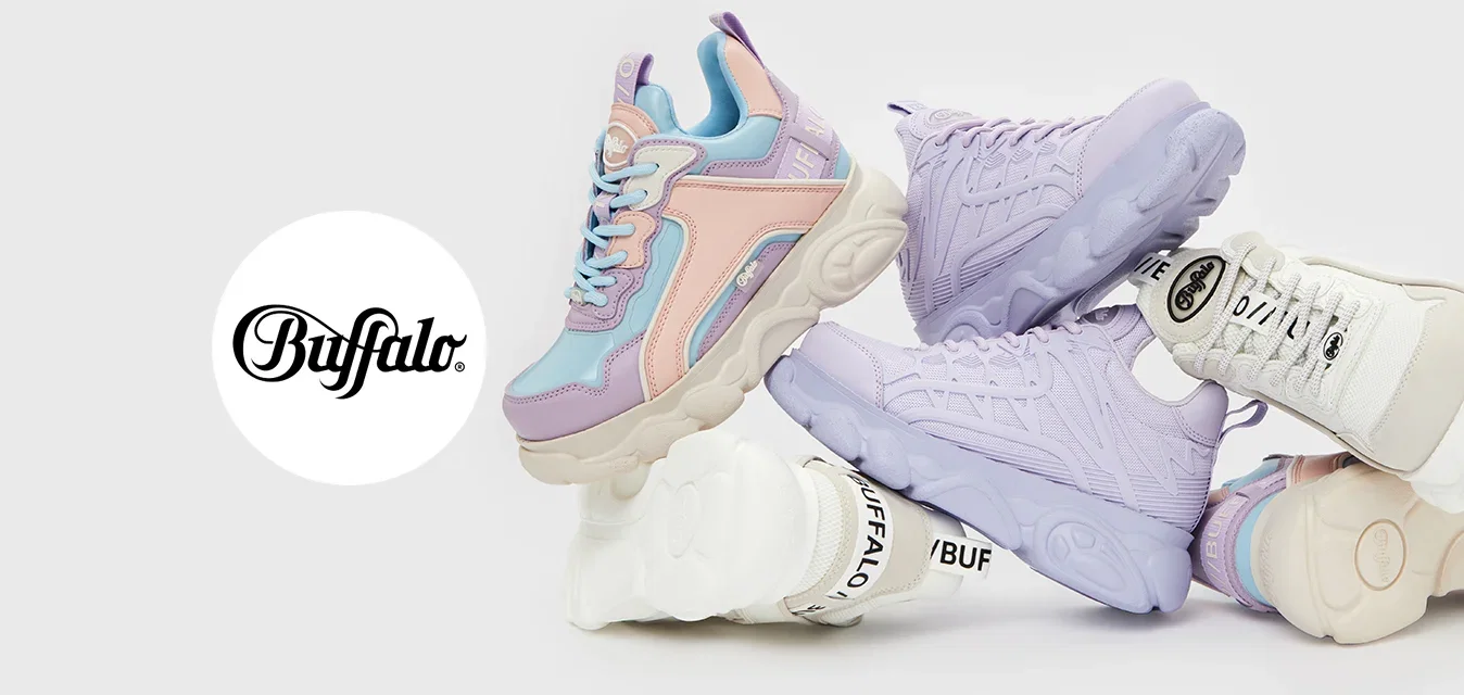 Zapatillas de colores en rosa, púrpura y blanco con texturas y diseños variados apiladas, presentando suelas distintivas y detalles de marca.
