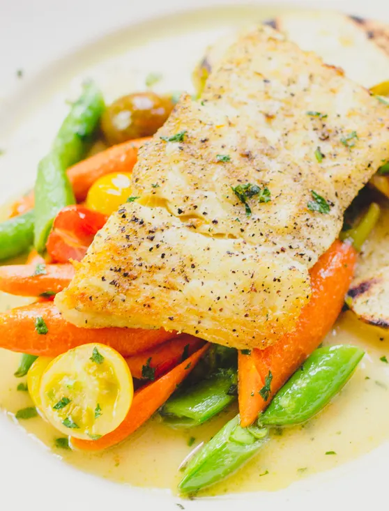 A colorful plating of halibut, baby carrots and snow peas at PlumpJack Cafe, the restaurant in PlumpJack Squaw Valley Inn in Squaw Valley, Calif., on Lake Tahoe's North Shore. The resort takes its name from a Shakespeare character.