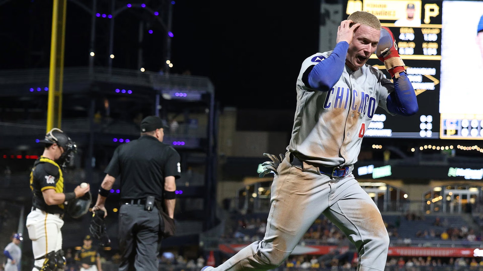 Pete Crow-Armstrong gestures to his ears to have a play at the plate reviewed