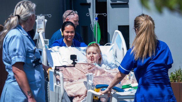 Hollie, 29, a patient at King's College Hospital, is wheeled onto the new rooftop intensive care unit in south London in her hospital bed, surrounded by three nurses dressed in blue uniforms.