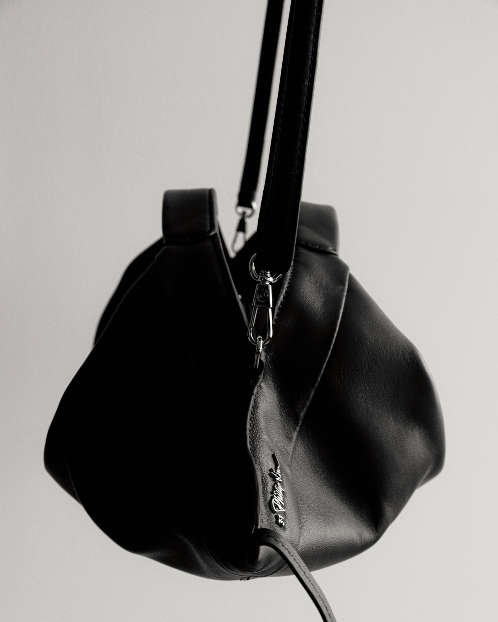an image of two black bags on a stand on a white surface