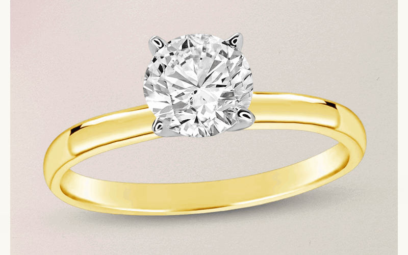 Gold ring band with 4-prong circle-cut diamond placed on center.